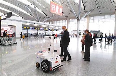 патрульный робот 5G проверяет температуру пассажиров в аэропорту Гуйян, Китай.